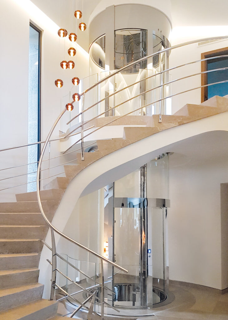 runde-aufzuege-giotto a living room with a large couch and glass doors